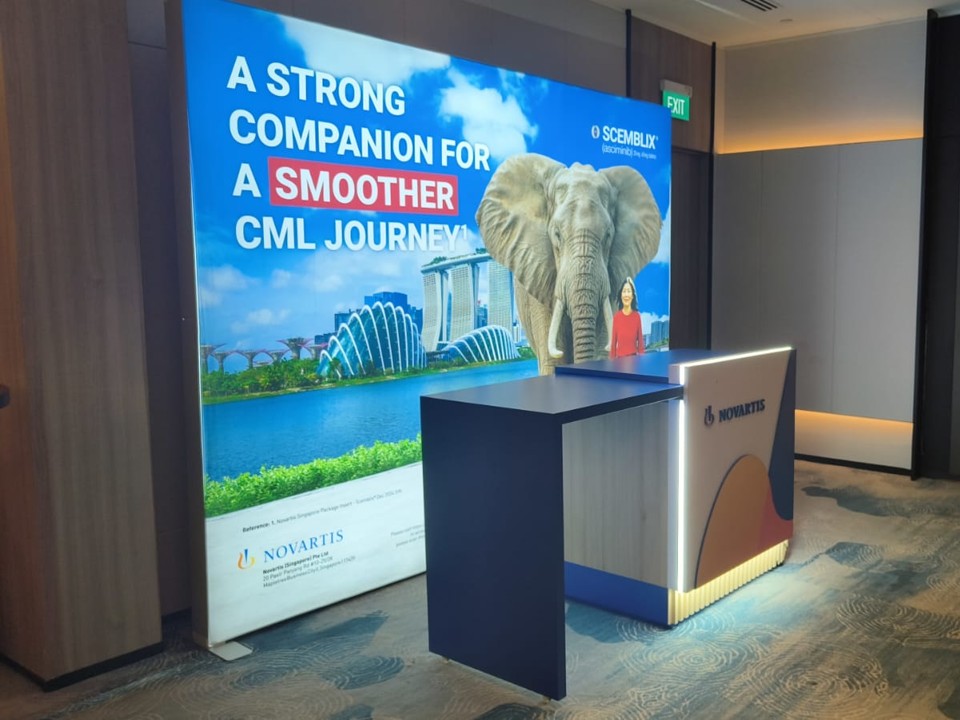 Registration counter with illuminated exhibition lightbox backdrop